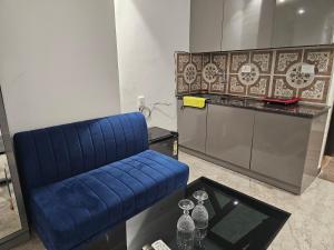 a blue couch in a room with a table at Ultra Luxury Apartment 814 By Bliss Stay in Zirakpur