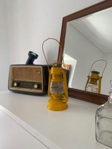 a table with a radio and a mirror at O Douro aqui tão perto in Santo Adrião