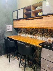 a kitchen with a counter with two chairs and a table at Keur lumières in Dakar +2 photos