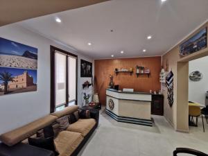 a living room with a couch and a kitchen at Il Giardino del Sol in San Vito lo Capo