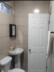a bathroom with a white toilet and a sink at Departamento en Rosarito in Plan Libertador