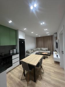 a kitchen and living room with a table and a couch at Mimi's Apartment in Durrës