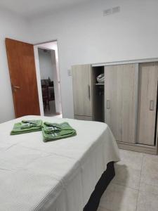 a white bed with green napkins on top of it at B&Z Departamentos in Federación
