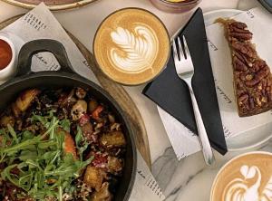 a table with a pan of food and two cups of coffee at Domain Boutique Rooms in Lancaster