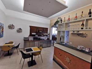 a restaurant with a counter and tables and chairs at Il Giardino del Sol in San Vito lo Capo