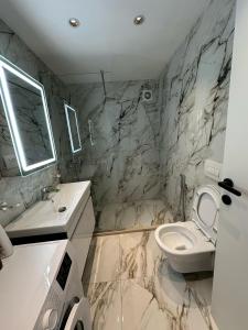 baño de mármol con aseo y lavamanos en Luxury Apartament Vlora, en Vlorë 5 fotos más