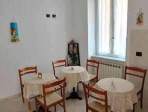 a dining room with two tables and chairs and a window at Ca' del Golfo in Levanto