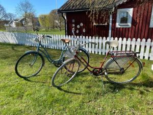 zwei Fahrräder im Gras neben einem Haus geparkt in der Unterkunft Sea Breeze Cottage in Färjestaden