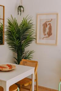 een eetkamer met een witte tafel en een plant bij Playa y Palmera in Corralejo