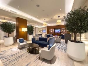 a lobby with a blue couch and chairs and a tree at The Address Residences Dubai Opera - Luxury 3BR Stay with Stunning Burj Khalifa & Fountain Views in Dubai