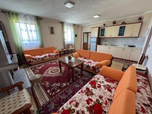 a living room with orange chairs and a table at Among cherries & Village in Salari