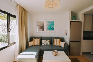 een woonkamer met een bank en een tafel bij Playa y Palmera in Corralejo +23 foto's