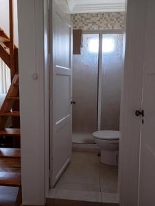 a white bathroom with a toilet and a staircase at Saint Peter´s House in Angra do Heroísmo +11 photos
