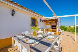 una sala da pranzo con tavolo e sedie su un patio di Quinta da Bisa - Casa das Pedrinhas ad Algoz