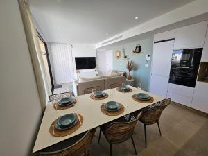 ein Esstisch mit Stühlen und eine Küche in der Unterkunft San Pedro Del Pinatar Penthouse in San Pedro del Pinatar