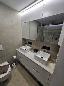 ein Badezimmer mit zwei Waschbecken, einem Spiegel und einem WC in der Unterkunft San Pedro Del Pinatar Penthouse in San Pedro del Pinatar