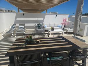 eine Terrasse mit einem Tisch, Stühlen und einem Sofa in der Unterkunft San Pedro Del Pinatar Penthouse in San Pedro del Pinatar