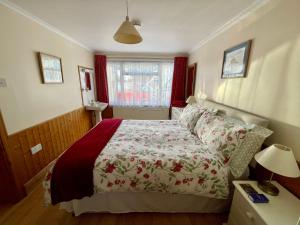 a bedroom with a bed with a red and white bedspread at Gem Cottage in Teignmouth
