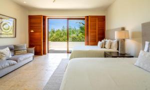 a hotel room with two beds and a couch at Terrazas, Treetop Hideaway with Golf Views in Punta Mita +29 photos