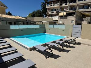 a swimming pool with lounge chairs next to a building at Alex Apartment Suites in Virós
