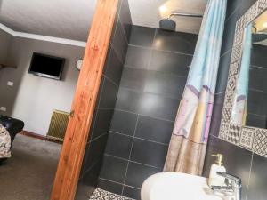 a bathroom with a sink and a shower with a mirror at Sailaway in Carbis Bay +37 photos