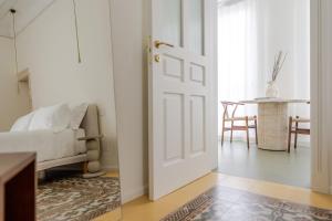 a living room with a white door and a couch at Garibaldi Luxury Suites in Noci