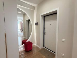 比什凯克SunHouse apartment的走廊里有一扇玻璃门和一把红色凳子