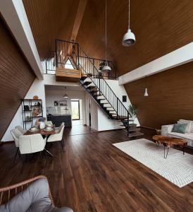 a living room with a staircase and a dining room at Kapa Chalet Bran in Sohodol