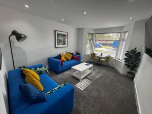 a living room with a blue couch and a table at Parkview holiday apartments GroundFloor in Skegness