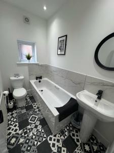 a bathroom with a tub and a toilet and a sink at Parkview holiday apartments GroundFloor in Skegness
