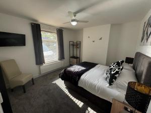 a bedroom with a bed and a ceiling fan at Parkview holiday apartments GroundFloor in Skegness