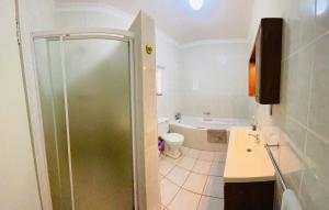 a bathroom with a shower and a toilet and a sink at Paradise Palms in Francistown +5 photos