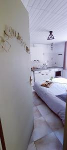 a white room with a bed and a kitchen at Studio confort montagne in Aulus-les-Bains +22 photos