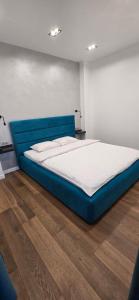 a large blue bed in a room with a wooden floor at ЖК Яровиця Люкс 2 поверх in Luts'k