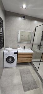 a bathroom with a washing machine and a sink at ЖК Яровиця Люкс 2 поверх in Luts'k