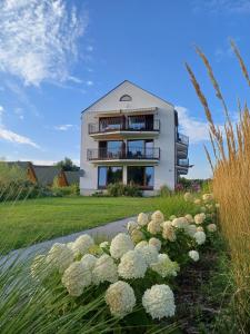 a building with a bunch of flowers in front of it at Apartamenty Na Fali in Jastarnia