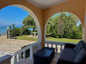 a balcony with a couch and a view of the ocean at Villa Antonia- Acharavi beach in Acharavi +43 photos
