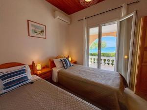 a bedroom with two beds and a large window at Villa Antonia- Acharavi beach in Acharavi