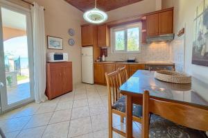 a kitchen with a wooden table and a table and chairs at Villa Antonia- Acharavi beach in Acharavi