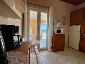 a kitchen with a door open to a balcony with the ocean at Villa Antonia- Acharavi beach in Acharavi