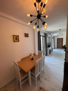 a dining room with a table and chairs and a chandelier at Villa Sara in Golem +10 photos