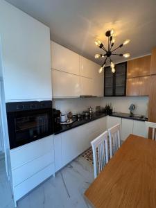 a kitchen with white cabinets and a table and a chandelier at Villa Sara in Golem