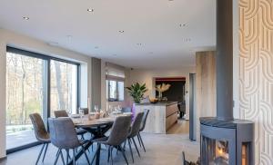a dining room with a table and a fireplace at Au bout du bois in Jalhay