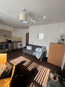 a living room with a couch and a kitchen at Chic Trafford Apartment, Private Underground Parking, Fast Wi-Fi, Self Check-in Anytime, 5 mins to Old Trafford Stadium in Manchester
