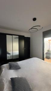 a bedroom with a large white bed and a chandelier at Casa Aurelia Archangelos in Archangelos