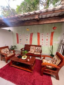 a living room with couches and a red rug at Vivenda Viviani in Praia