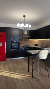 a kitchen with black cabinets and a table with a chair at Casa Aurelia Archangelos in Archangelos