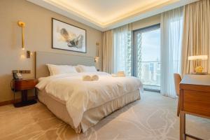 a bedroom with a large bed and a large window at The Address Residences Dubai Opera - Luxury 3BR Stay with Stunning Burj Khalifa & Fountain Views in Dubai +98 photos