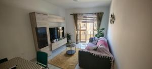 a living room with a couch and a tv at Sea view three bedroom apartment in Is-Sellum