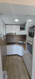 a kitchen with white cabinets and a wooden floor at Vila Piramida - Zavojsko jezero-Pirot in Bukorovac +8 photos